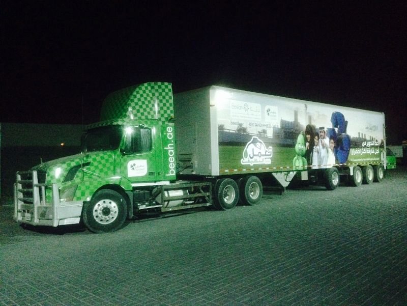 Green campaign graphics on an articulated truck